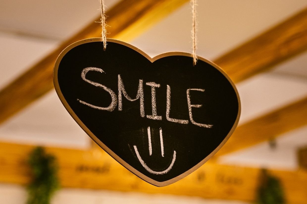 Pizarra con forma de corazon y la palabra Smile en el comedor