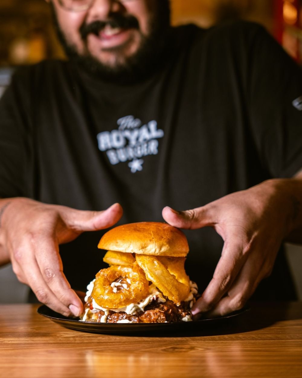Un miembro del equipo presenta una hamburguesa recien montada